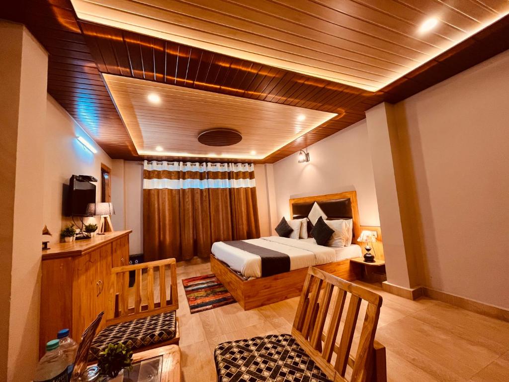 a bedroom with a bed and a television in a room at Sana cottage - Affordable Luxury Stay in Manali in Manāli