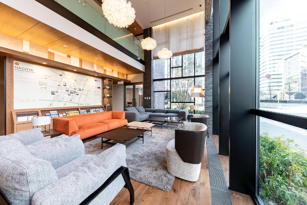 a lobby with couches and tables and a large window at Nishitetsu Hotel Croom Nagoya in Nagoya