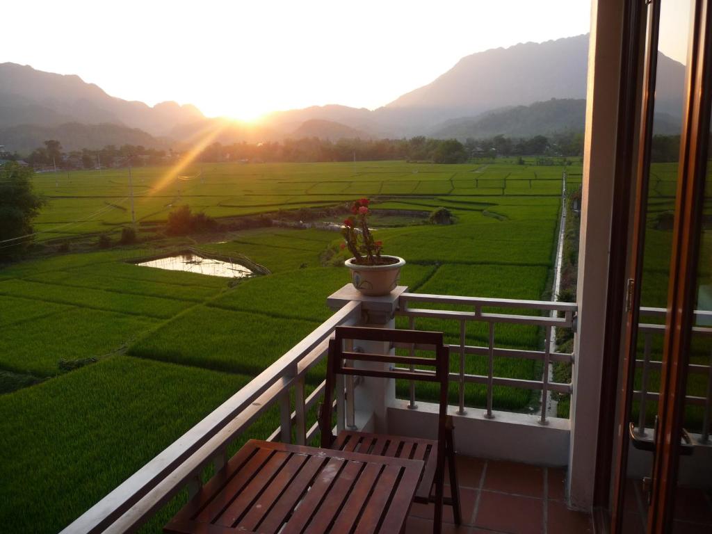 a balcony with a view of a green field at Mai Chau Valley View Hotel in Mai Chau