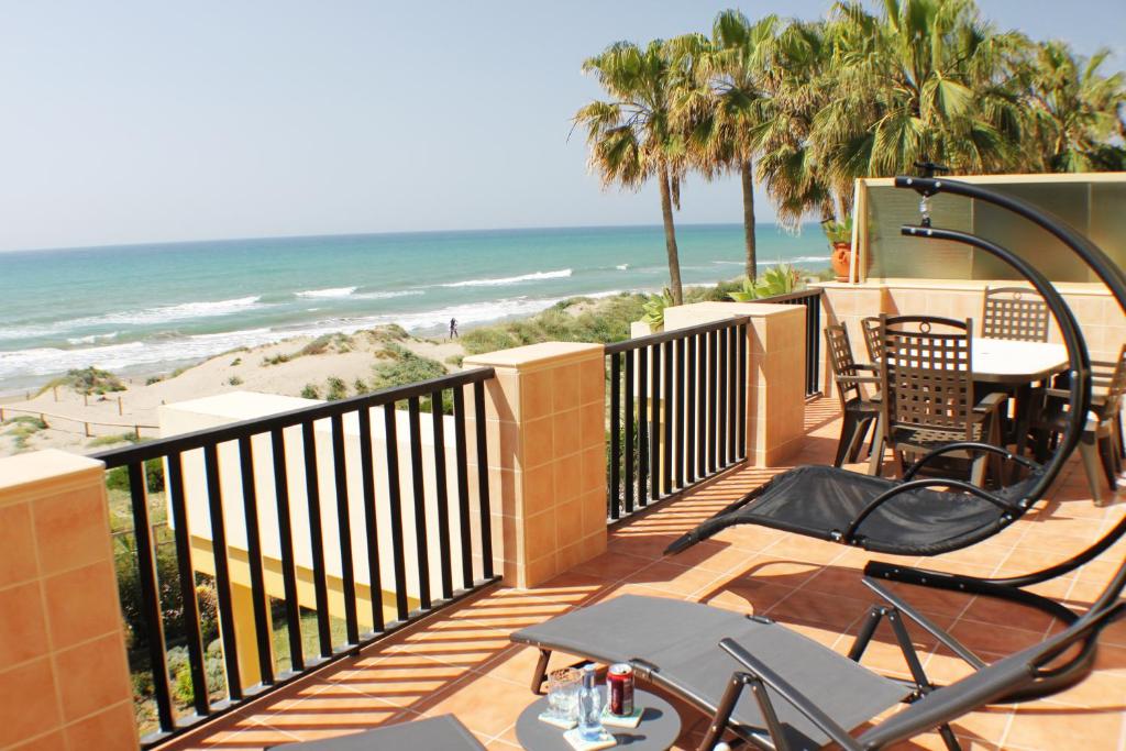 a balcony with a table and chairs and the beach at Romana Playa in Marbella