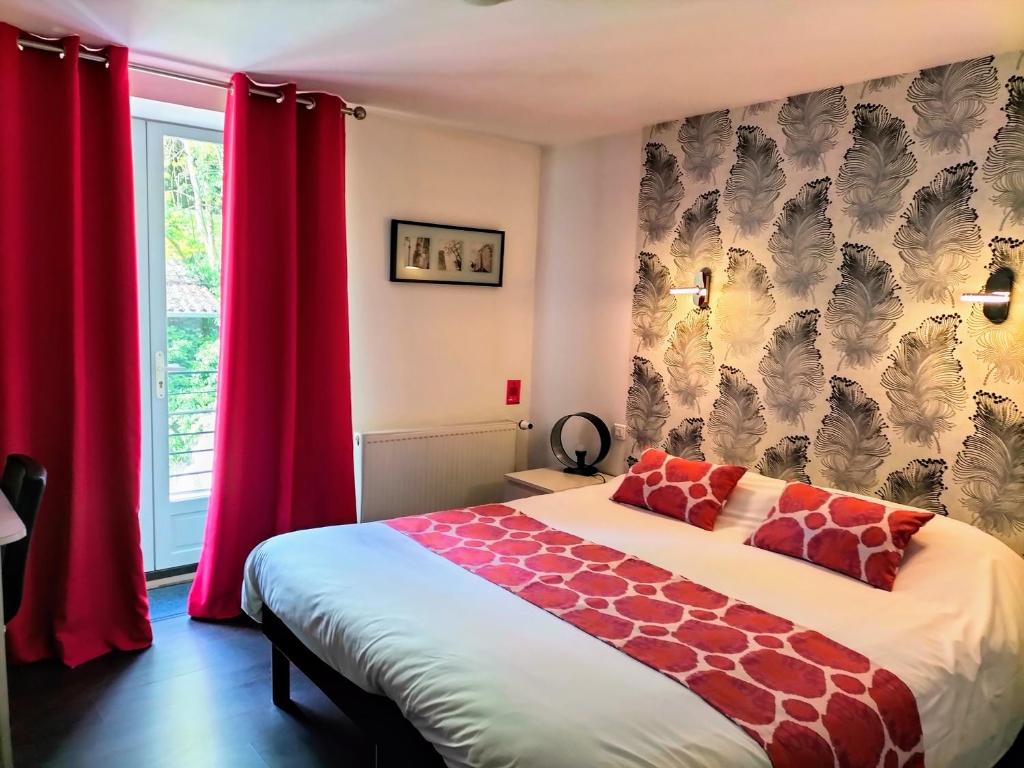 a bedroom with a bed with red curtains at Hotel Restaurant Herard in Bourbonne-les-Bains