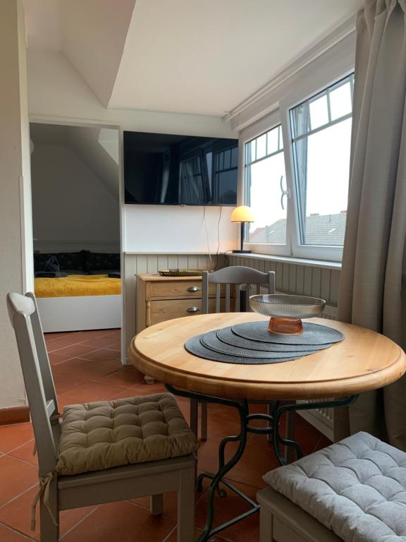 ein Esszimmer mit einem Tisch und ein Schlafzimmer in der Unterkunft Huus Mövchen in Borkum