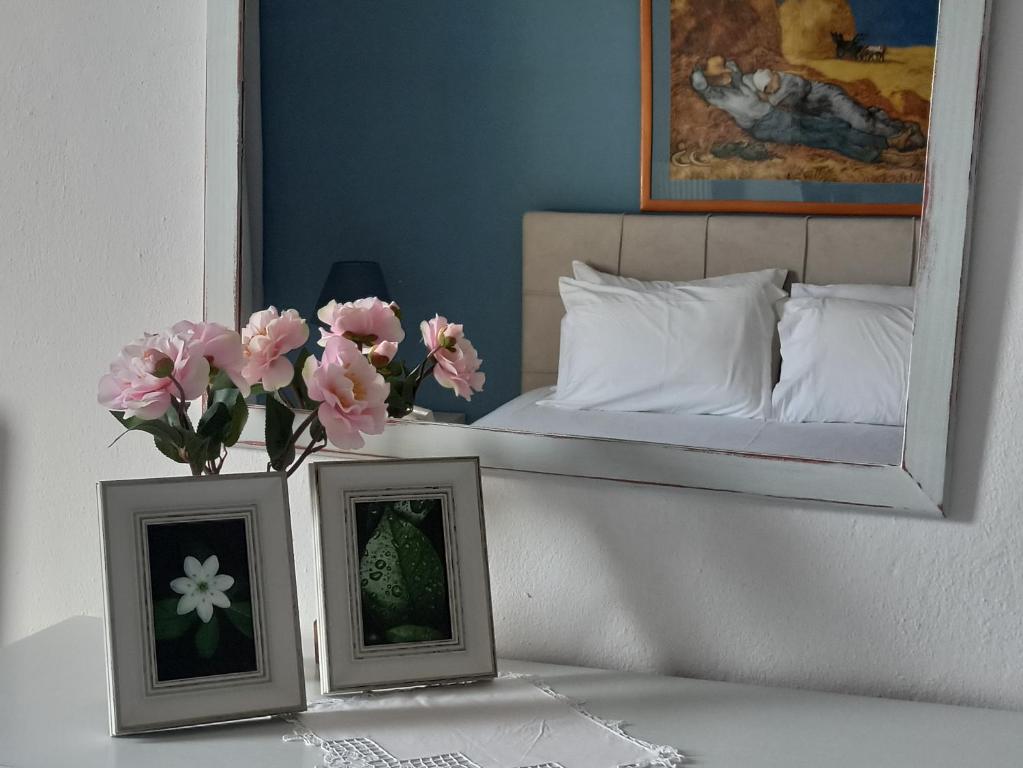 dos fotos en una mesa junto a una cama con flores en Dora's House comfortable apartment with a yard and view, en Pyrgadikia