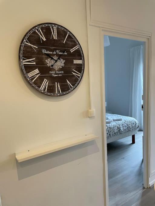 eine Uhr, die an einer Wand in einem Raum hängt in der Unterkunft Cosy T3 proche Gare et Polygone in Béziers