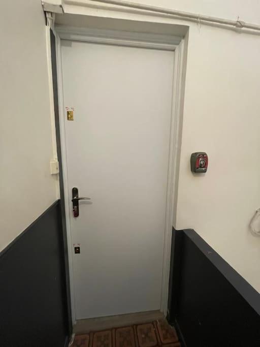 eine weiße Tür in einem Zimmer mit einer Uhr drauf in der Unterkunft Cosy T3 proche Gare et Polygone in Béziers
