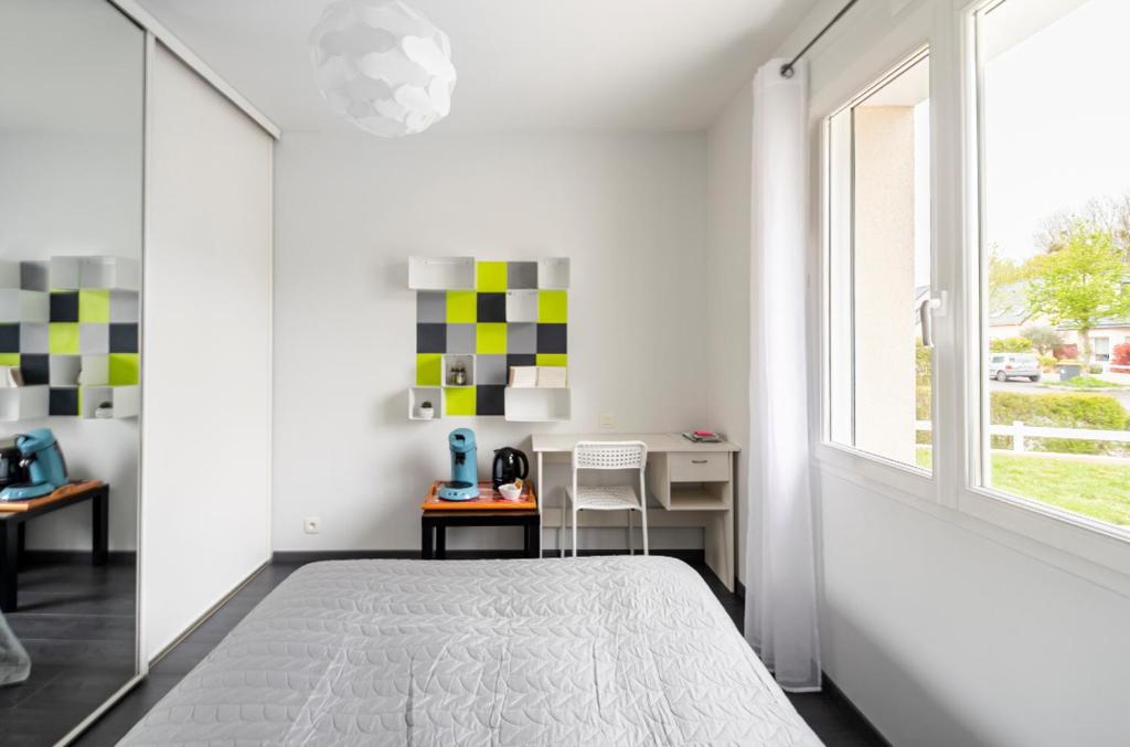 a white bedroom with a bed and a window at L escale bretonne- séjour chez l habitant in Mordelles