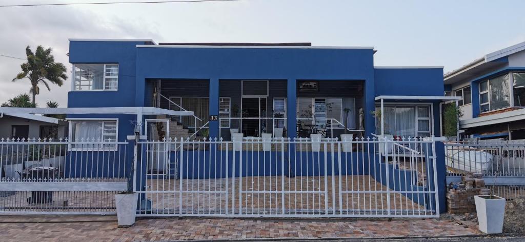 een blauw huis met een hek ervoor bij Tranquility in Parow
