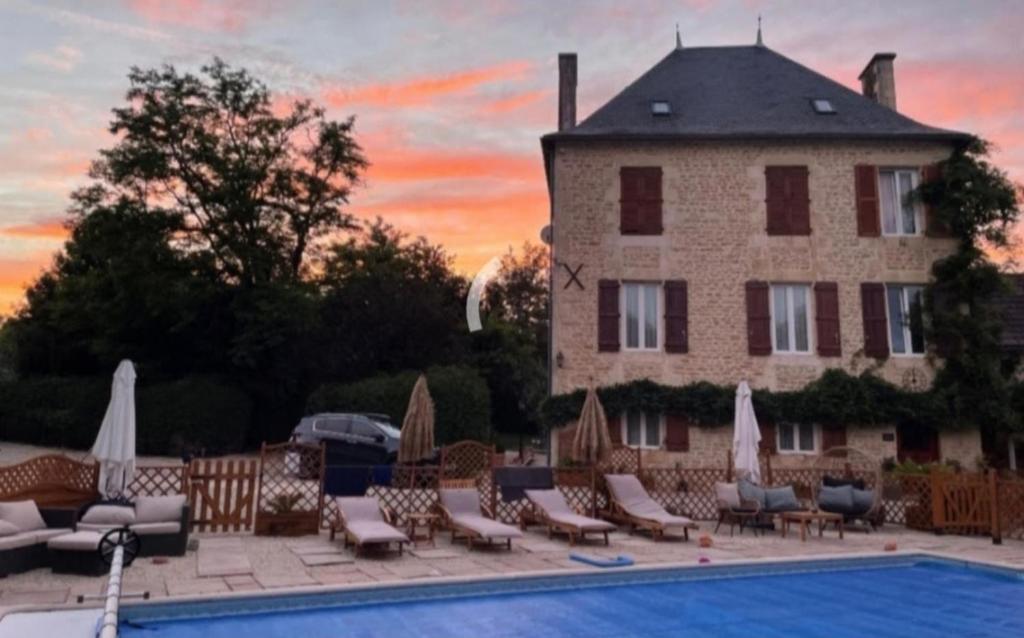 ein Hotel mit einem Pool und Stühlen sowie einem Gebäude in der Unterkunft Inviting 3-Bed holiday home in Chateau-Garnier in Château-Garnier