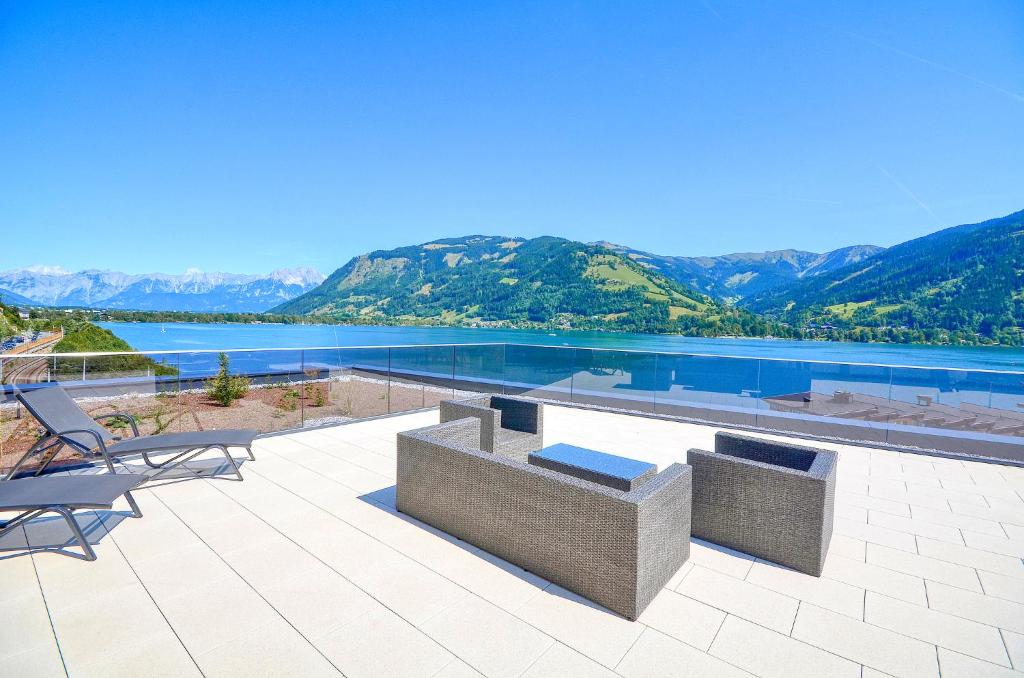 a patio with a view of a lake and mountains at Alpin & Seeresort Penthouse 18 - by Alpen Apartments in Zell am See
