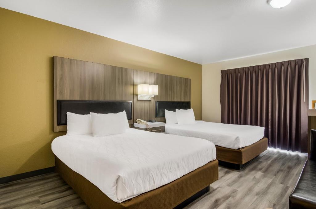 um quarto de hotel com duas camas e uma janela em Rodeway Inn Enumclaw Mount Rainer-Crystal Mountain Area em Enumclaw