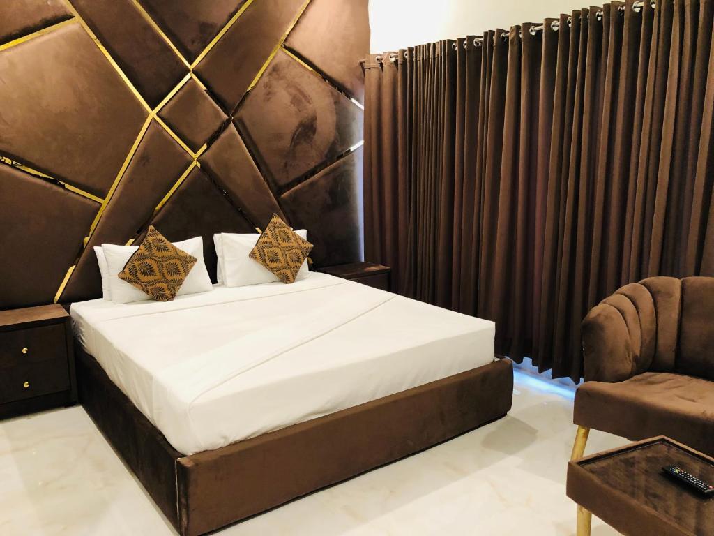 a bedroom with a large bed and a chair at Star House in Islamabad