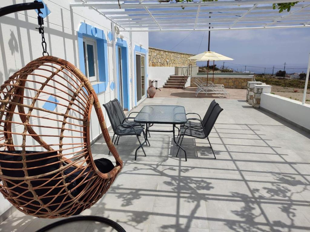 a patio with chairs and a table and an umbrella at Villa Otos in Afiartis