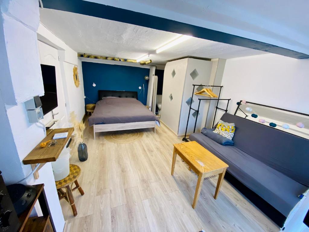 Jolie chambre indépendante في ليموج: غرفة كبيرة بها سرير وأريكة
