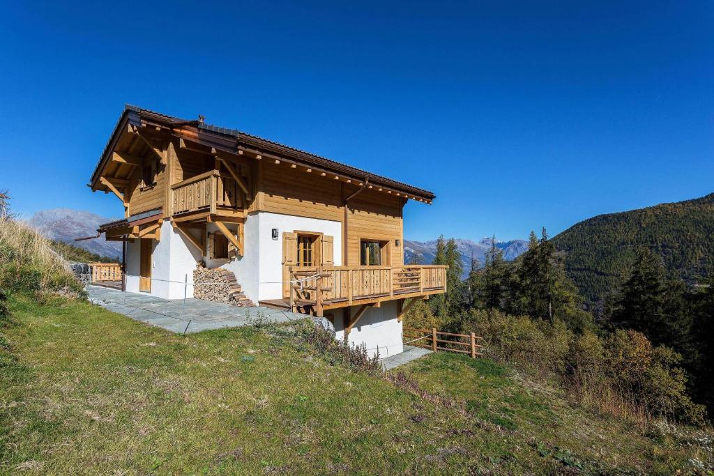 a small wooden house on a hill in the mountains at Chalet Grand Roi in La Tzoumaz