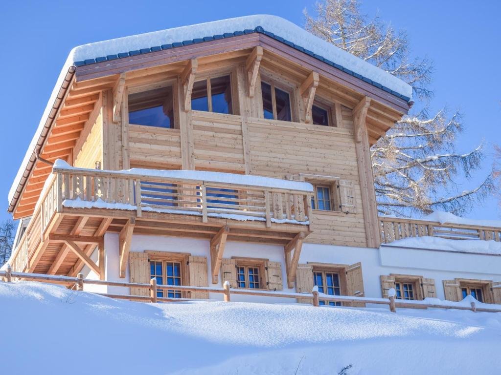 a log cabin in the snow with a balcony at Chalet Grand Roi in La Tzoumaz