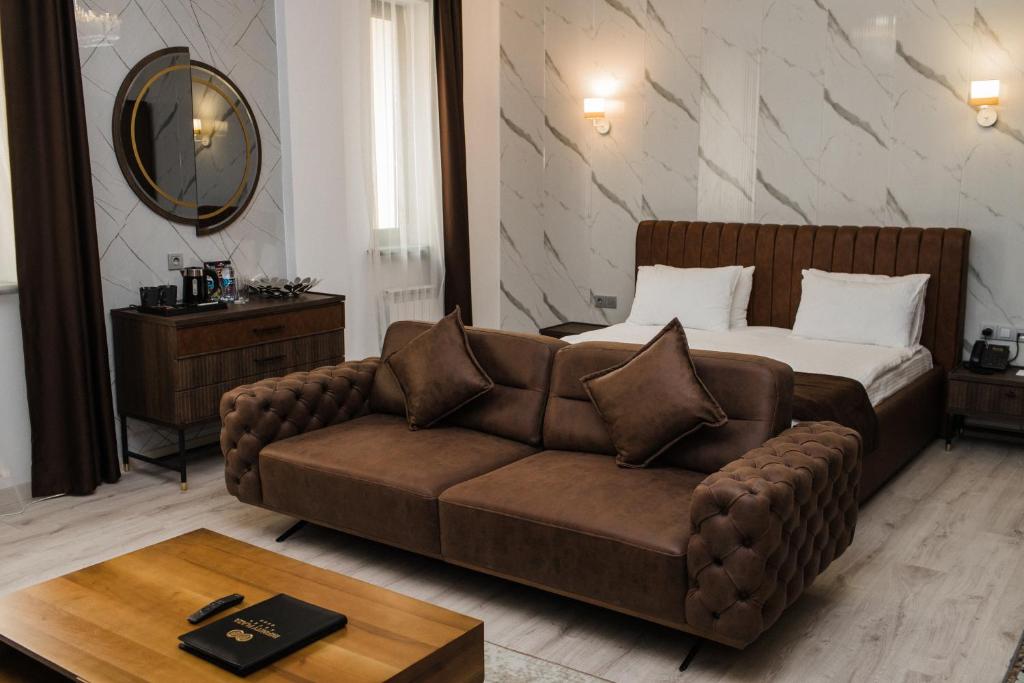 ein Hotelzimmer mit einem Sofa und einem Bett in der Unterkunft INFINITY PLAZA BLOCK 1 in Atyrau