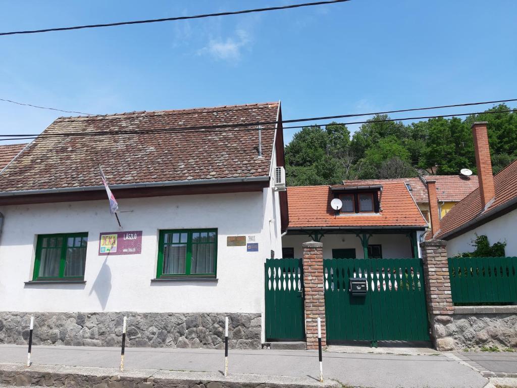 a white house with a green gate at LÁSZLÓ Turistaszálló in Visegrád