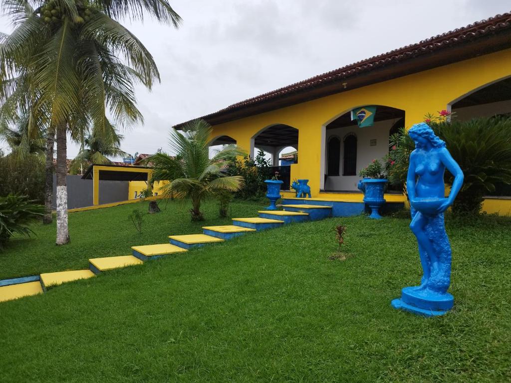 une statue bleue dans l'herbe devant un bâtiment dans l'établissement Casa com Piscina 50000 litros Área Gourmet 3 Suites no Destacado, Bairro mais Nobre de Salinas, à Salinópolis