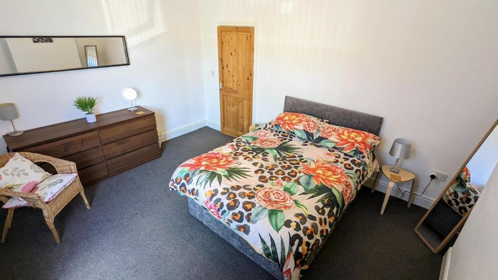 Schlafzimmer mit einem Bett, einer Kommode und einem Spiegel in der Unterkunft The Lawrence, 2 Bedroom Victorian House in Redcar