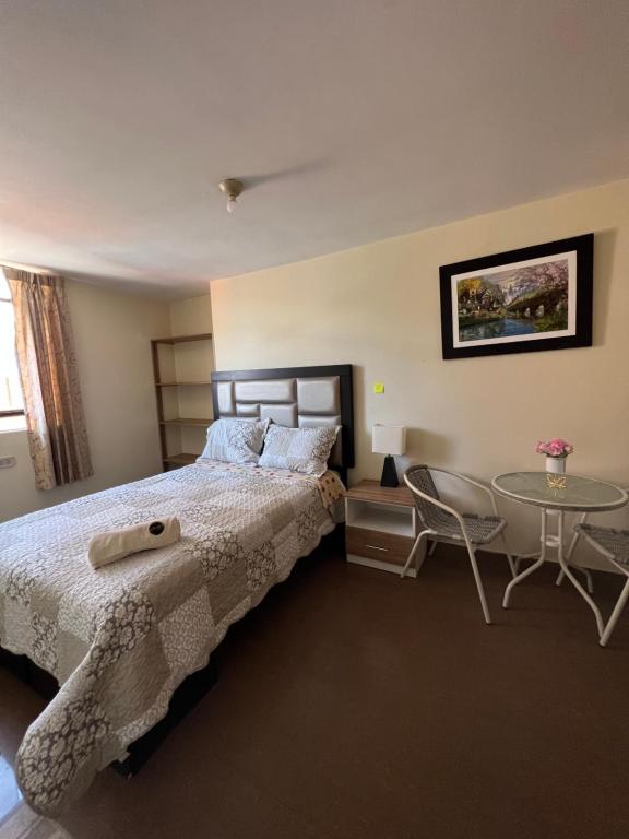 um quarto com uma cama e uma mesa em Antara Hostal em Cajamarca