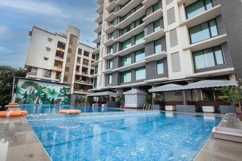 an empty swimming pool in front of a building at Ramee Techome in Mumbai