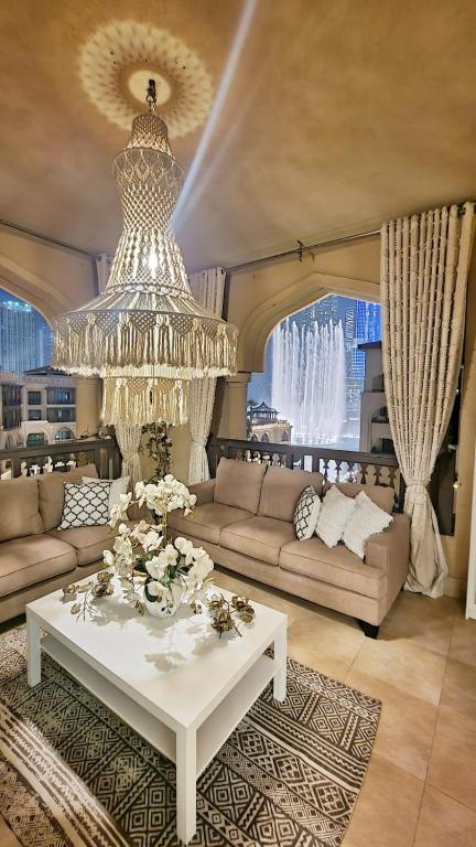 a living room with a chandelier and a white table at ULTIMATE DXB DOWNTOWN PENTHOUSE in Dubai