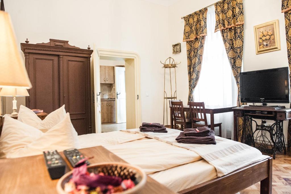 Brukenthal Central Apartments Sibiu في سيبيو: غرفة نوم مع سرير مع وعاء من الفواكه على طاولة