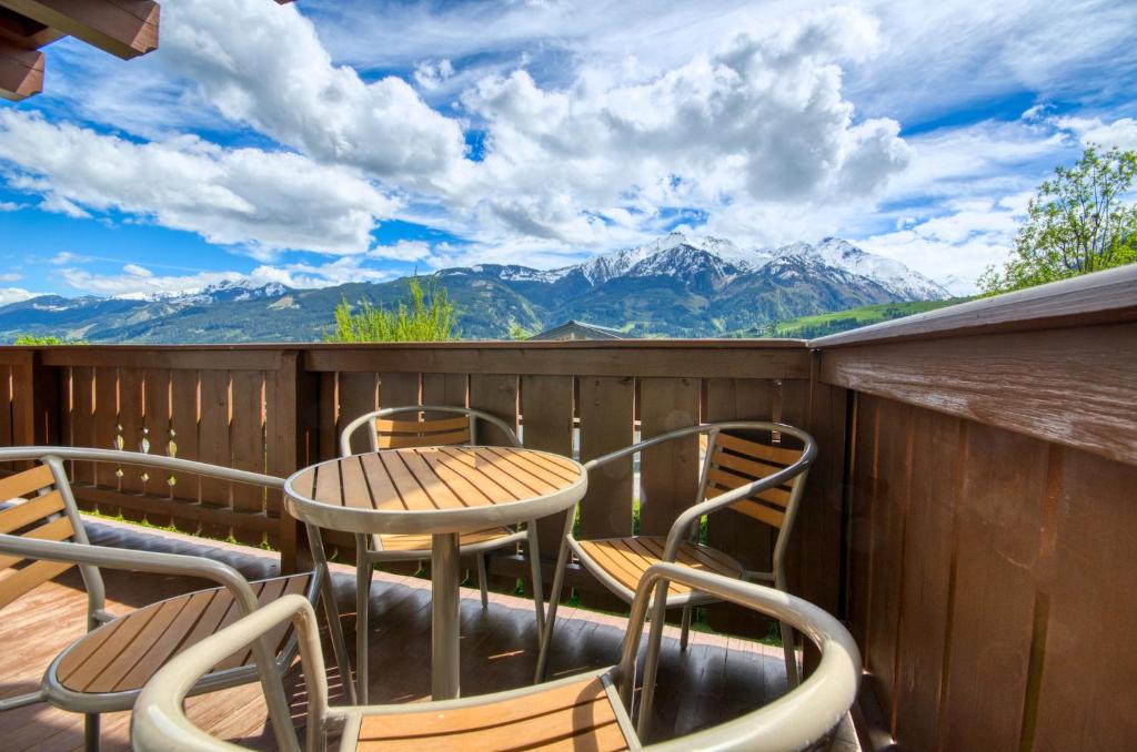 a table and chairs on a deck with mountains at Select Top 4 - by Alpen Apartments in Piesendorf