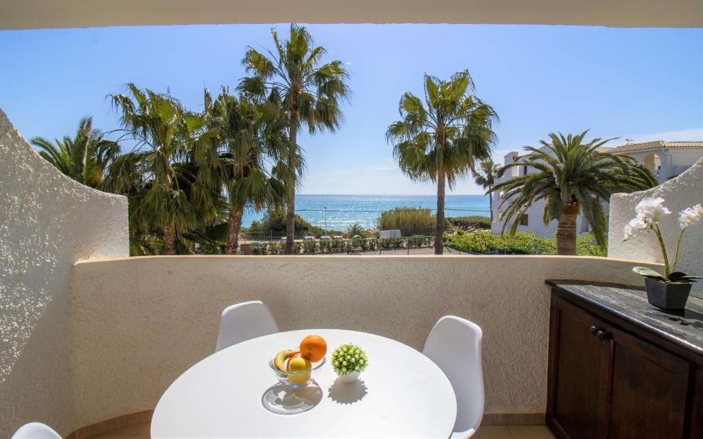 una mesa y sillas en un balcón con vistas al océano en PRIMERA LINEA Playa Romana Frontal al Mar ALBERT VILLAS en Alcocéber