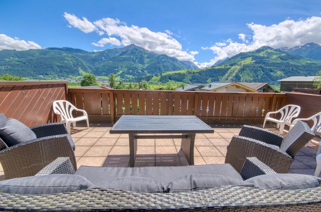 a patio with a table and chairs and mountains at Select Top 7 - by Alpen Apartments in Aufhausen