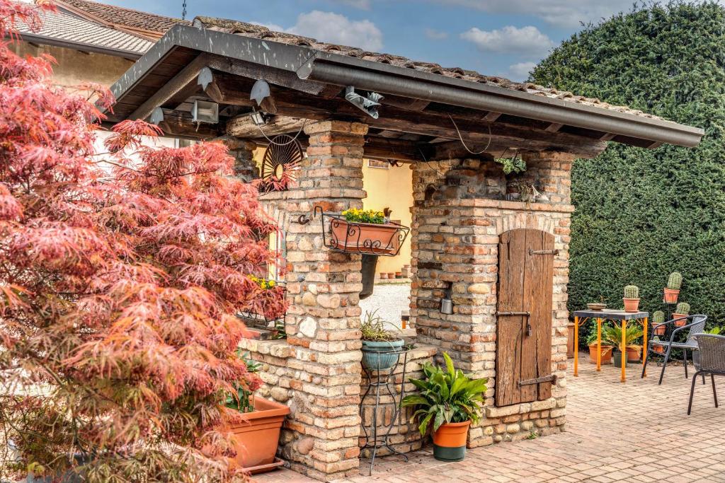 a brick building with a wooden door and a patio at Agriturismo Pozzo Fiorito in Castiglione delle Stiviere
