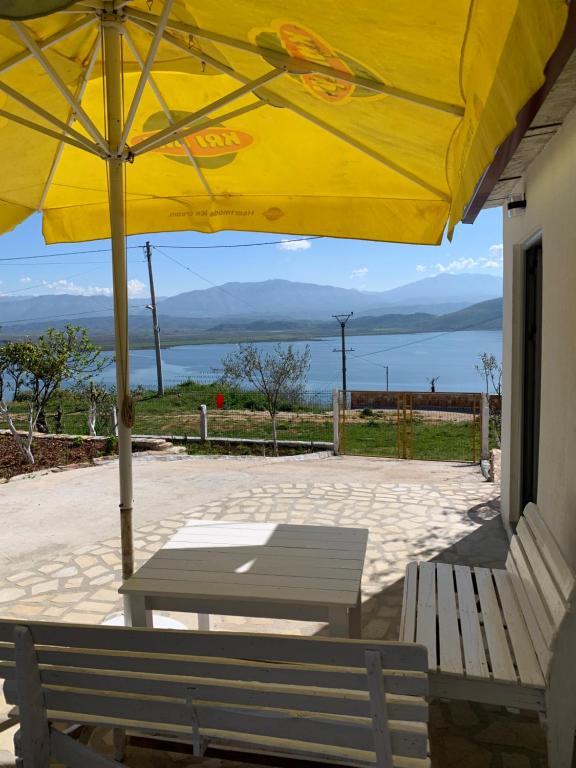 a yellow umbrella over a table and two benches at Villas Ermali in Ksamil