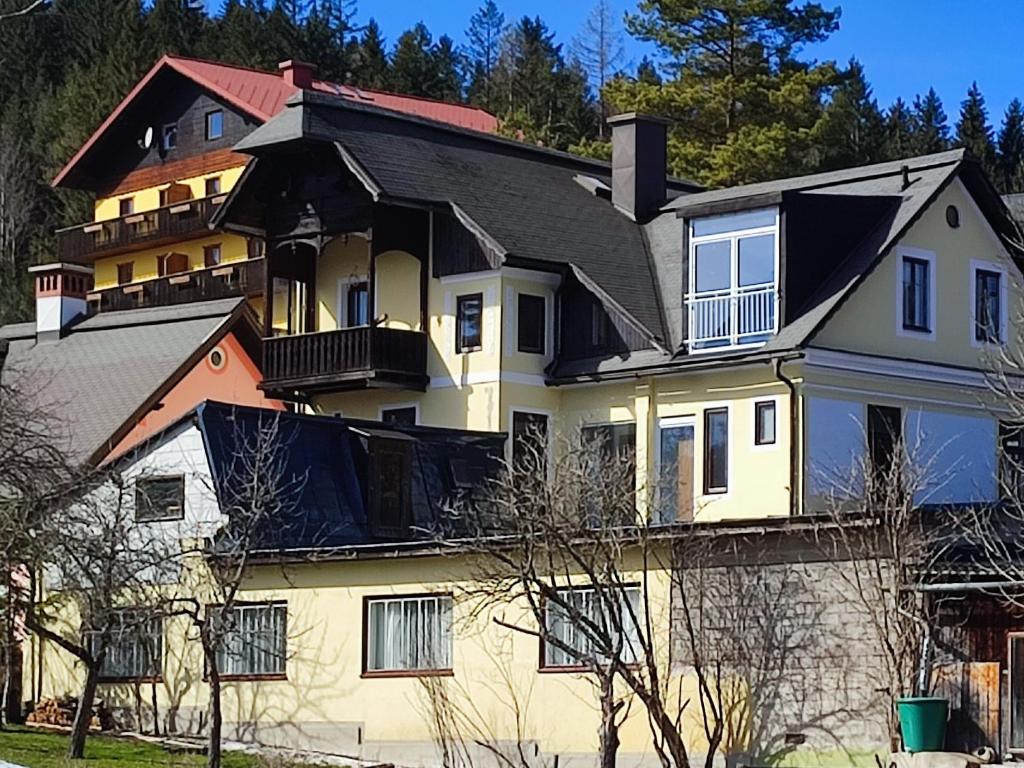 a large white house with a black roof at Nur 3 Min zu Skilift & 5Min zum See in Mitterbach