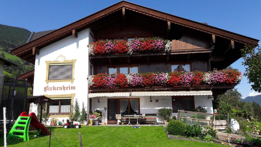 a house with flower boxes on the side of it at Ferienwohnung Birkenheim in Fügenberg