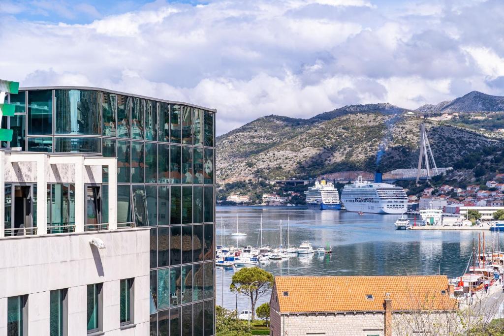 a building next to a body of water with boats at Apartment Dubrovnik Clouds in Dubrovnik