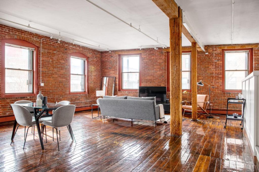 a living room with brick walls and a table and chairs at S End Loft w Pool Art Gallery Steps to T BOS-356 in Boston