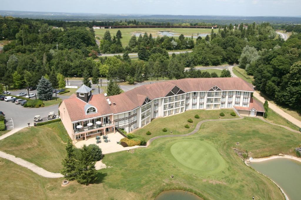 呂扎什的住宿－格爾福蒙格力風酒店，享有带高尔夫球场的度假建筑的空中景致
