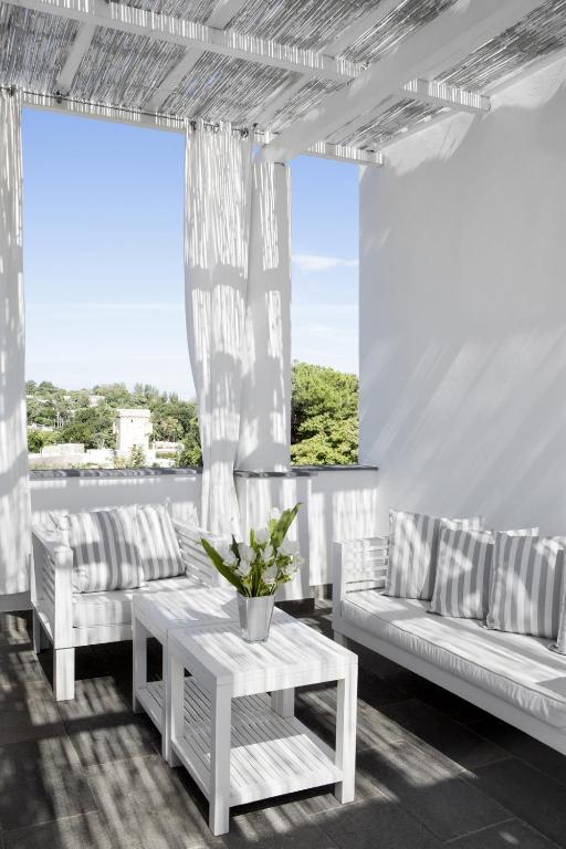 a living room with white couches and a table at La Suite Boutique Hotel in Procida