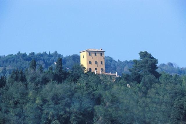 ein Gebäude auf einem Hügel mit Bäumen in der Unterkunft Locanda Di Villa Torraccia in La Torraccia