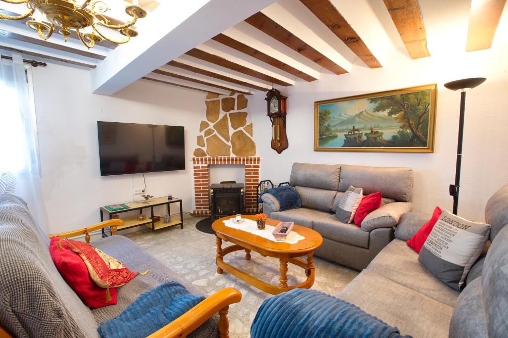 een woonkamer met banken en een tv en een tafel bij Cuencaloft Zarzuela in Zarzuela