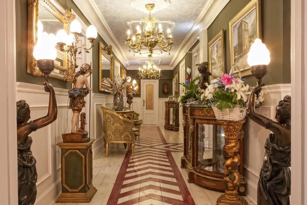 a hallway with statues and a chandelier at H. Boutique Puerta del Sol in Torrelavega