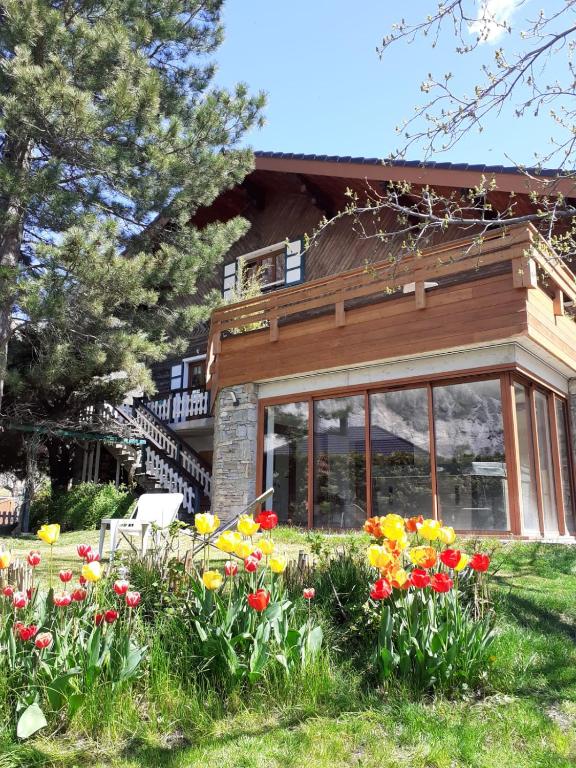 une maison avec un bouquet de fleurs dans la cour dans l'établissement La Marmotte de la Tour, à Hermillon