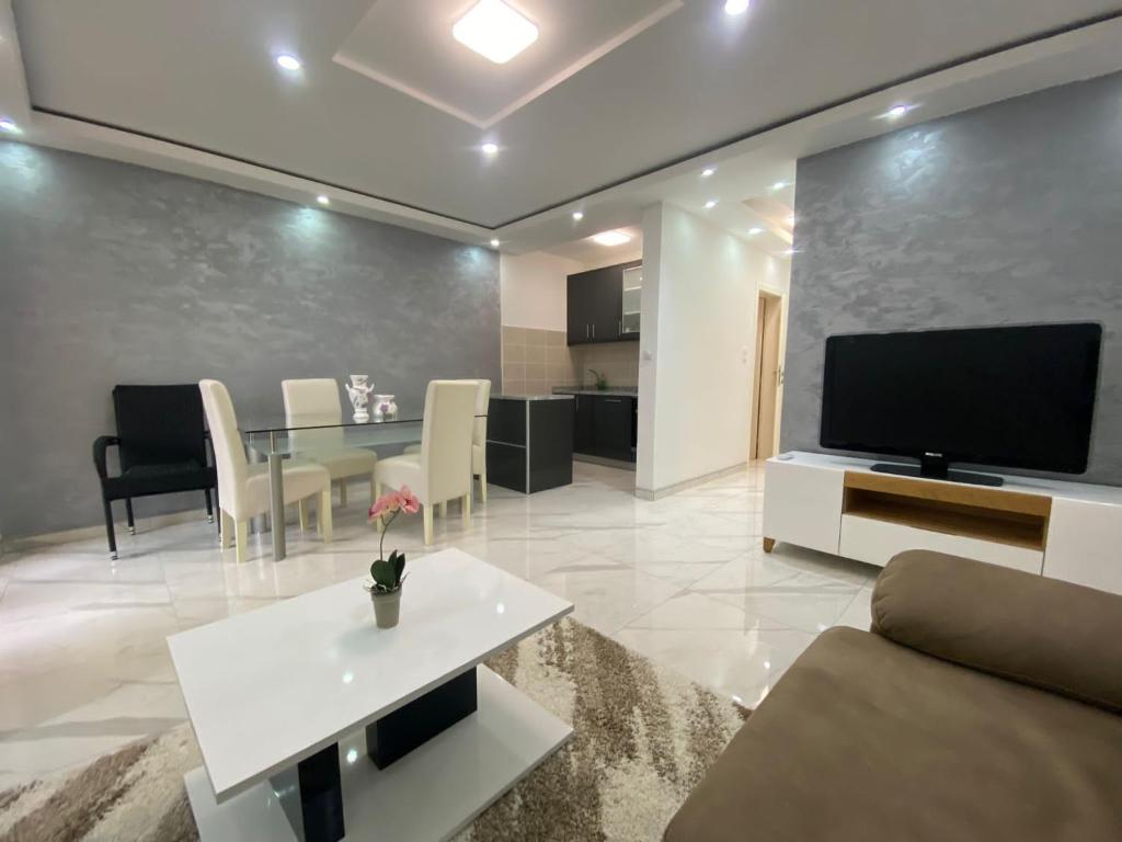a living room with a couch and a tv and a table at Apartman Stivi Deluxs 2 in Vrnjačka Banja