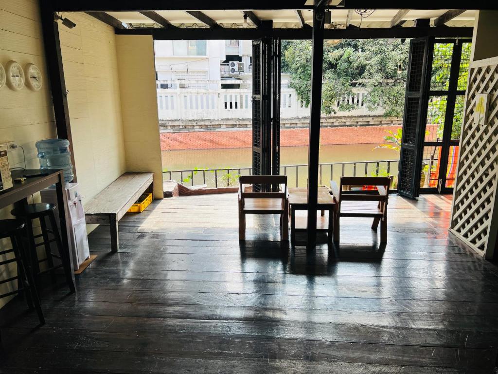 Pokój z 2 krzesłami, stołem i oknami w obiekcie 146 Canal w mieście Bangkok