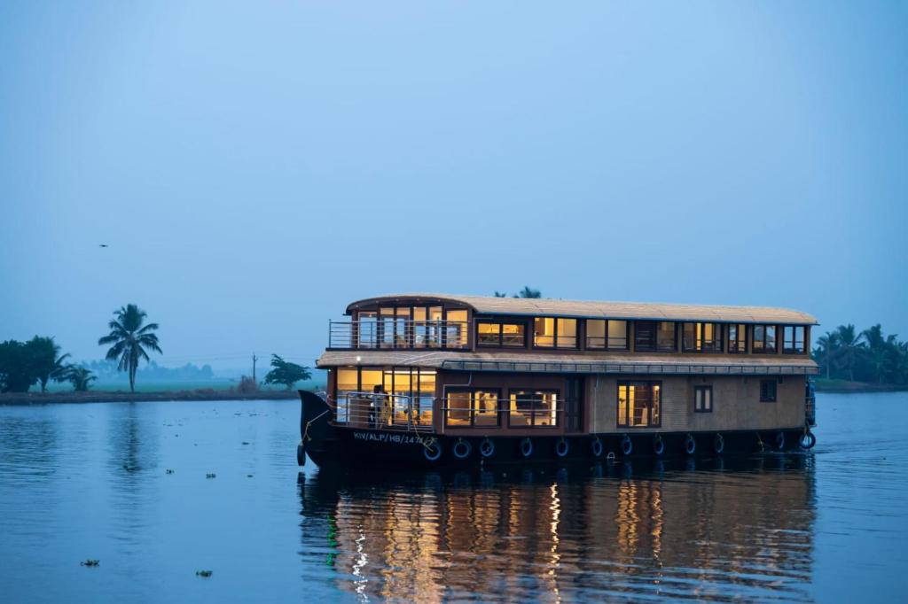 a house boat on the water at dusk at Kerala Boathouse in Alleppey