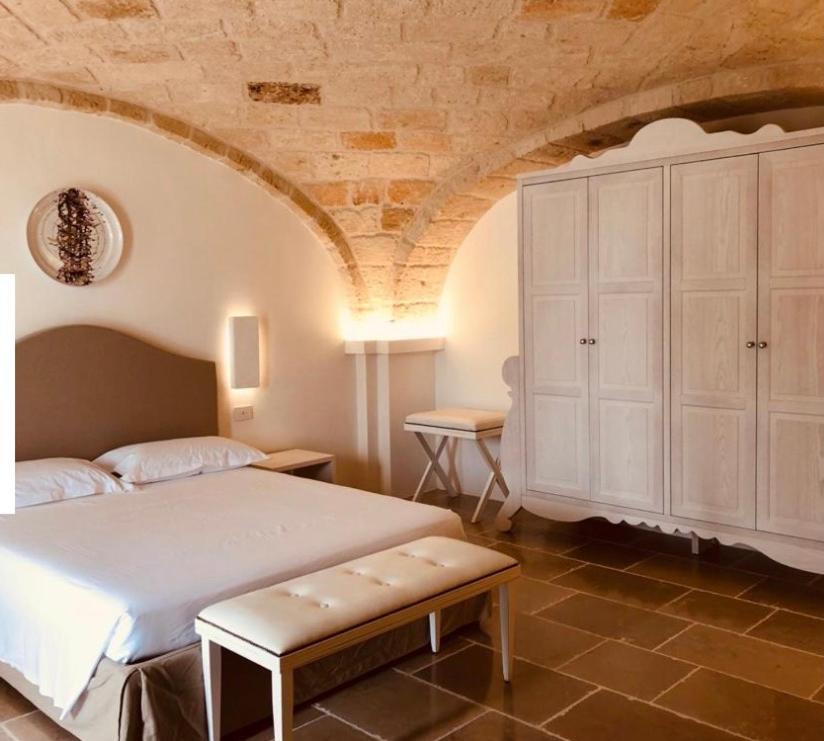 um quarto com uma cama e um armário branco em BIANCHEMURA B&B em Monopoli