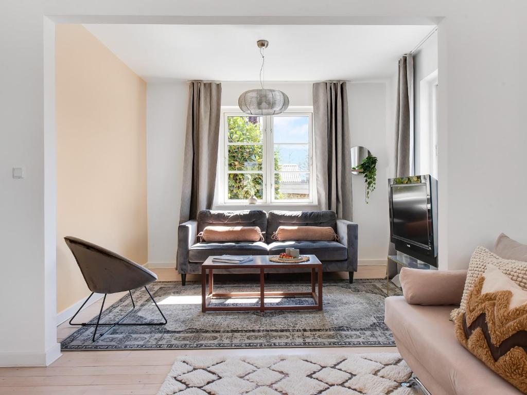 - un salon avec un canapé et une table dans l'établissement Sanders Charm - Endearing Two-Bedroom Apartment with Shared Garden, à Copenhague