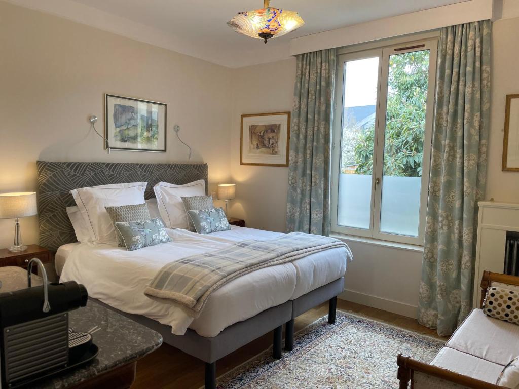 um quarto com uma cama e uma grande janela em La Villa de Chinon em Chinon