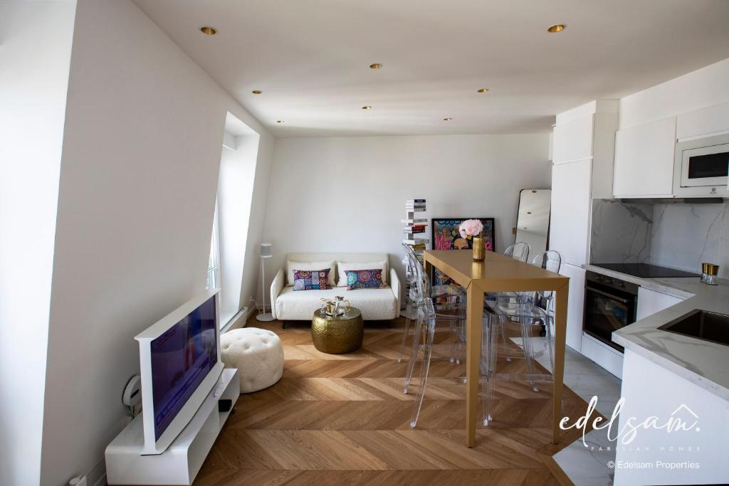 a kitchen and living room with a television and a table at Paris Parc Monceau by Edelsam in Paris