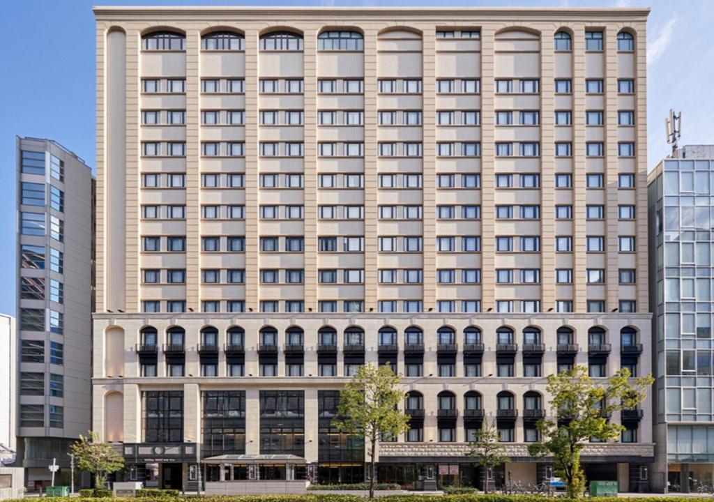 a large building in front of some buildings at Welina Hotel Premier Nakanoshima West in Osaka